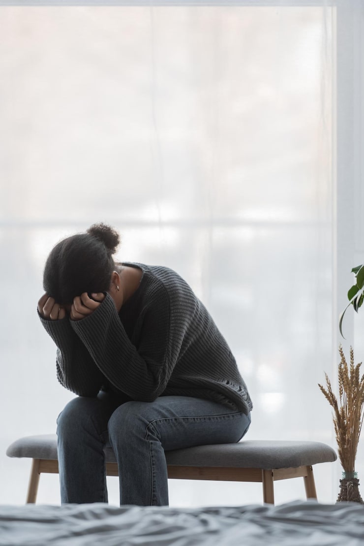 person sitting with head down showing emotional distress during a mental health therapy session in Chicago